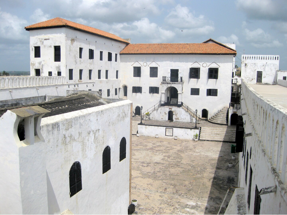 Photographie de St. George Castle à Elmina au Ghana : l'image représente une cour vide au milieu d'un bâtiment aux murs blancs. Aucune trace de l'esclavage n'est visible.